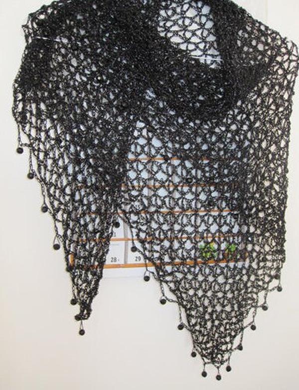 Black beaded crochet shawl hanging flat, full triangular view with beaded points along the hem.