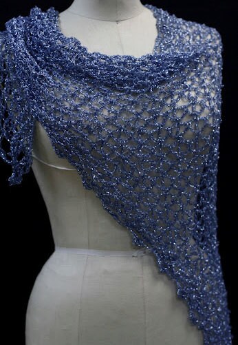 Blue lurex shawl on a mannequin, three-quarter view showing how it drapes over the shoulder.