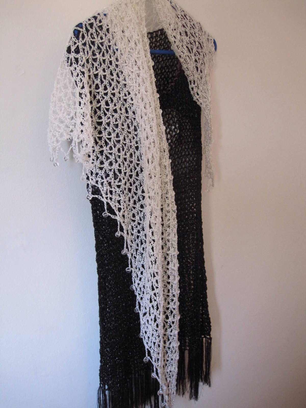 Cream crochet shawl over a black dress, alternate angle showing the soft drape.