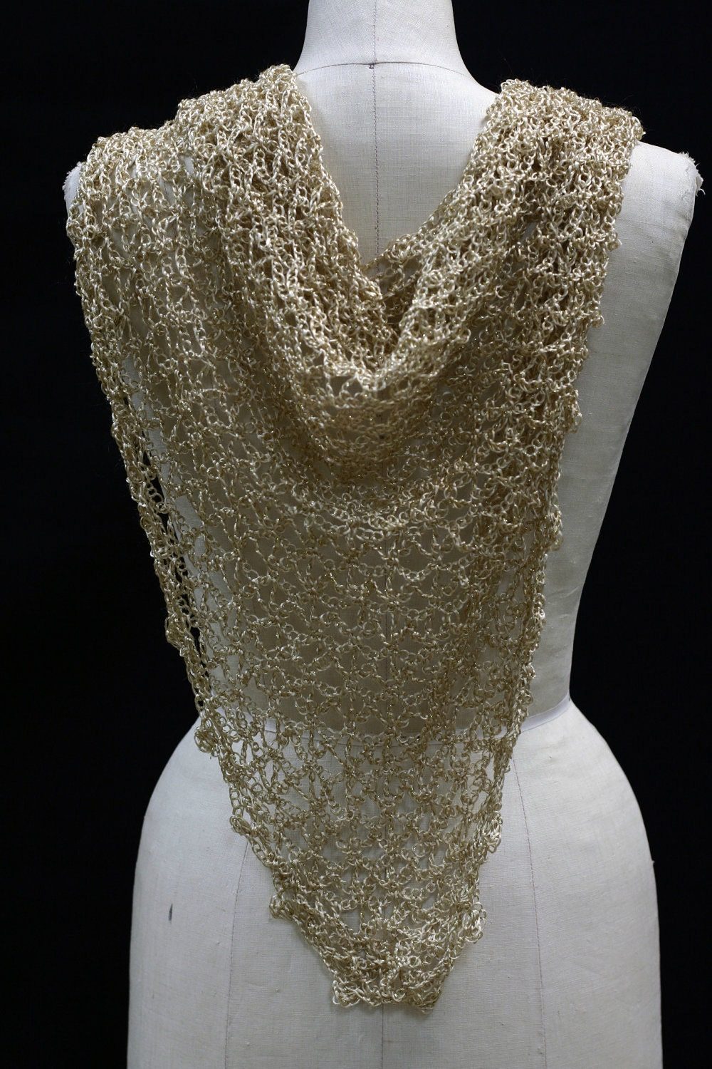 Back view of the gold lurex shawl on a mannequin, showing how the beaded triangle wrap falls down the back.