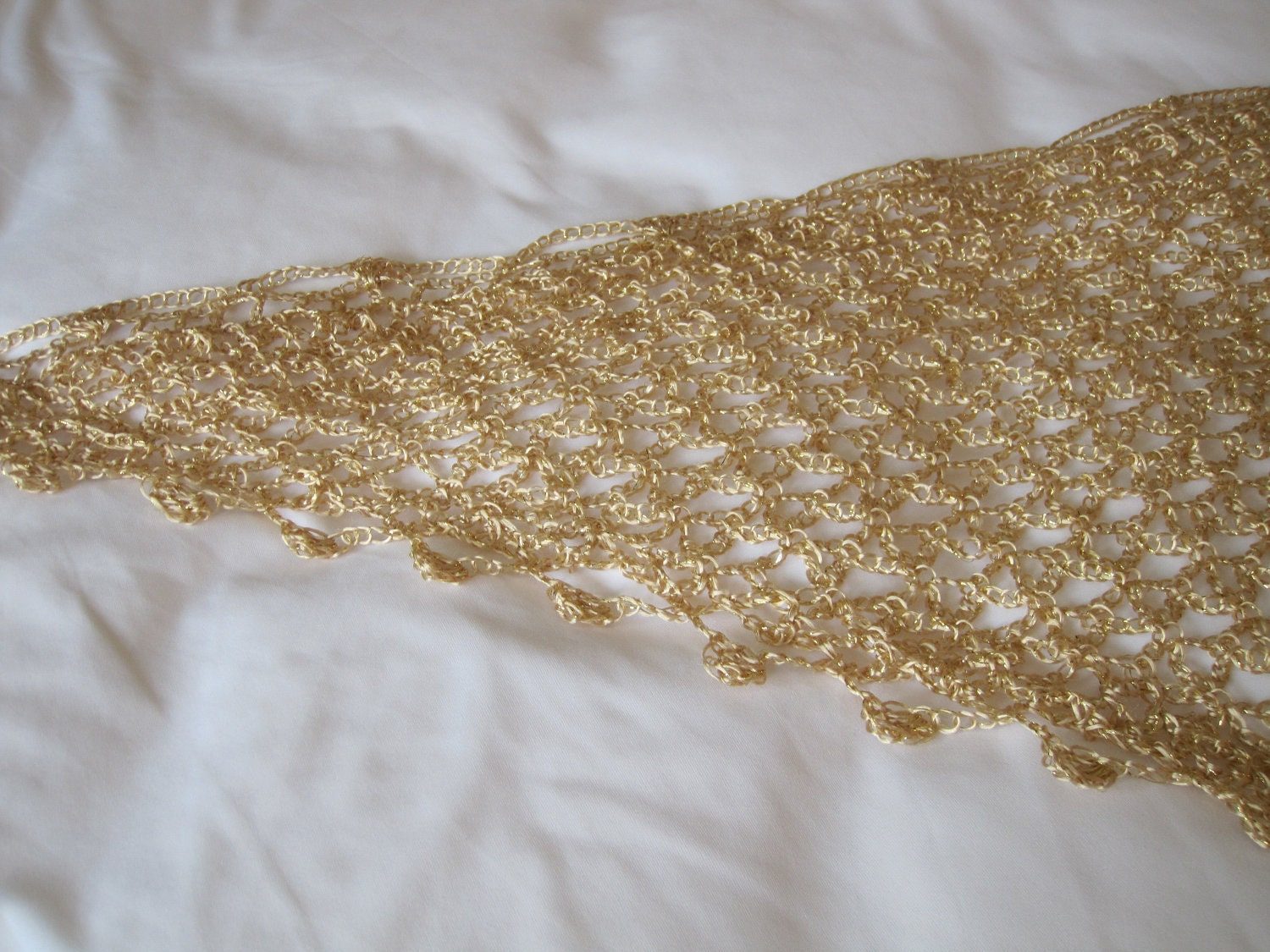 Close-up of the gold lurex crochet edge, revealing tight hand stitches and small beads along the scalloped trim.