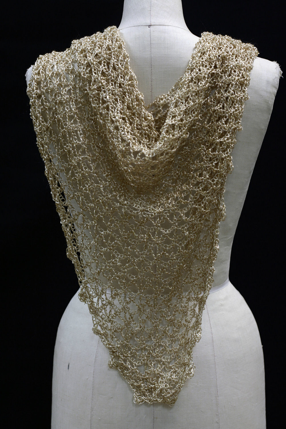 Back view of the gold lurex bridal shawl on the mannequin, the beaded triangle falling down the back.