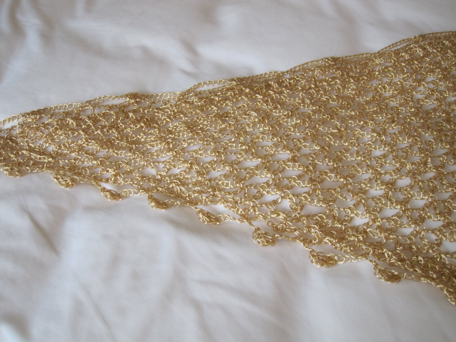 Close-up of the gold lurex crochet edge, revealing small beads set along the scalloped trim.