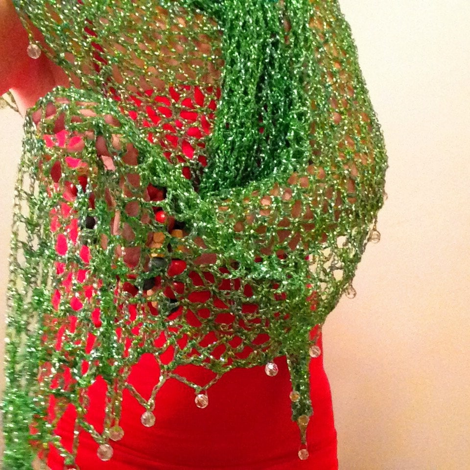 Green beaded lurex shawl draped over a red dress, lower view showing the hanging bead fringe along the hem.