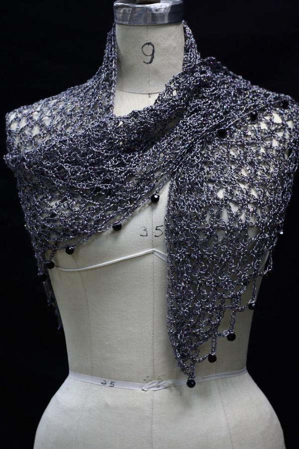 Grey beaded crochet shawl draped on a dress-form mannequin, front view with dark beads along the edge.