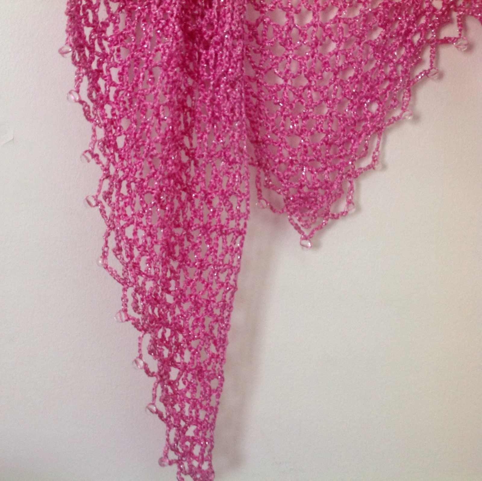 Close-up of the pink openwork crochet, showing the fine stitches and beaded edge.