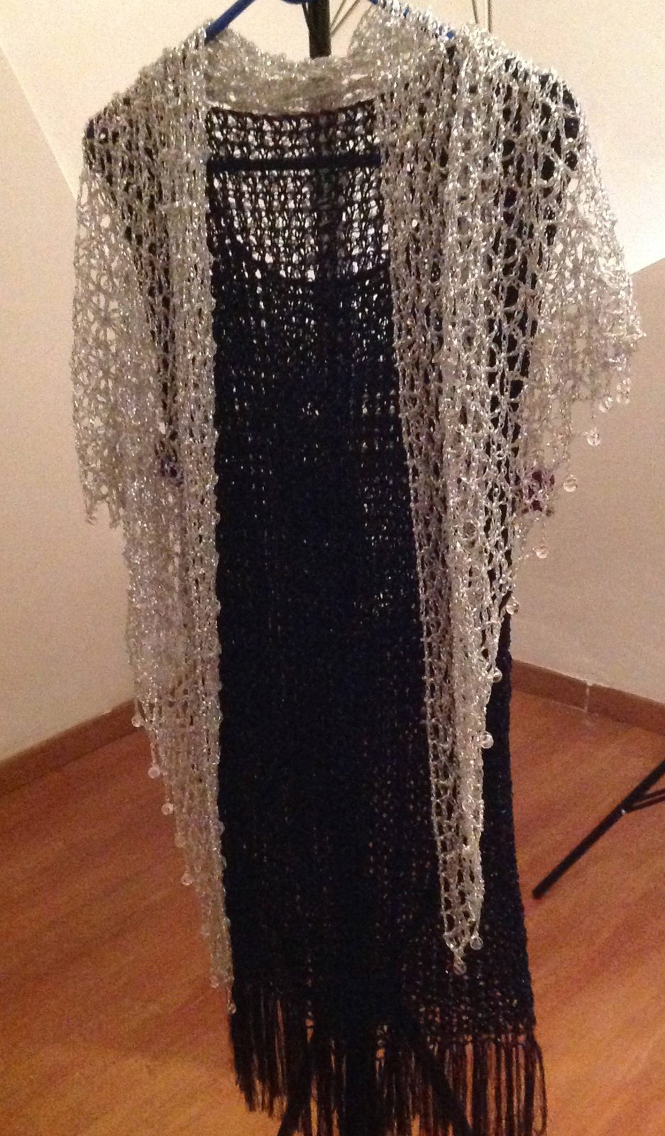 Silver beaded shawl over a black dress, alternate angle showing how the shimmering crochet falls along the body.