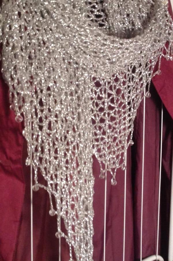 Close-up of the silver lurex shawl over a burgundy garment, showing the beaded edge and openwork crochet.