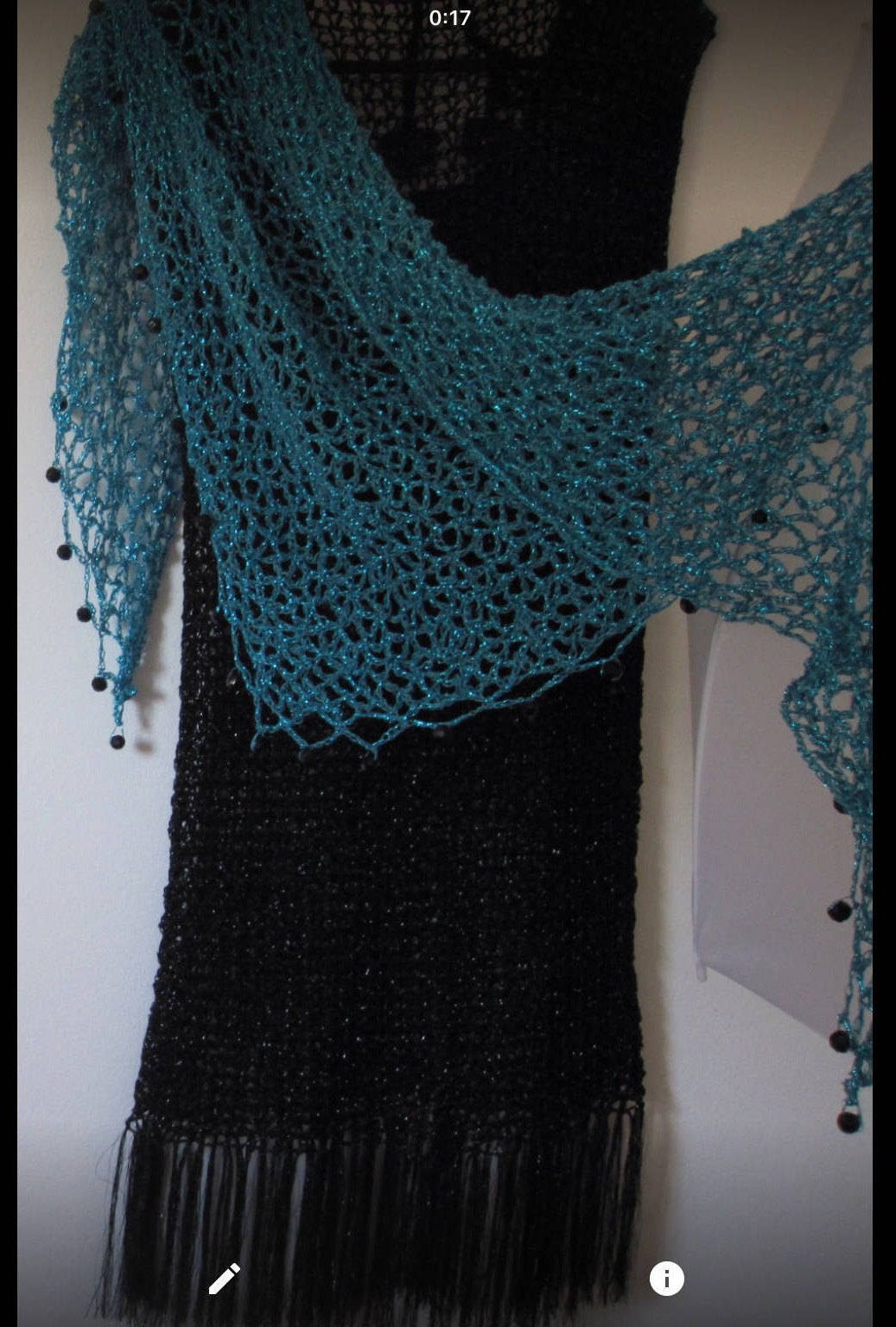 Closer view of the turquoise shawl on the black dress, showing the soft cowl drape and beaded openwork.