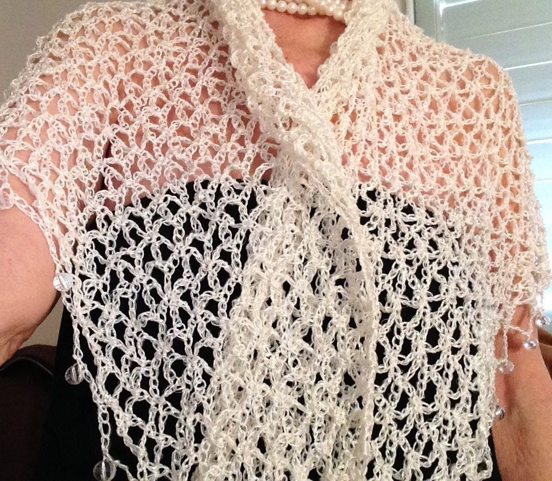 White shawl worn over the shoulders, front view of the soft cowl drape and beaded edge.