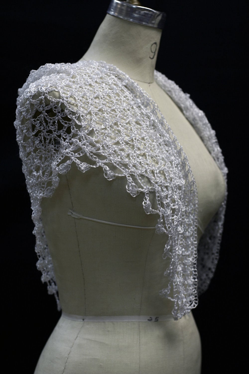White shawl on the mannequin, alternate angle of the soft shoulder drape.